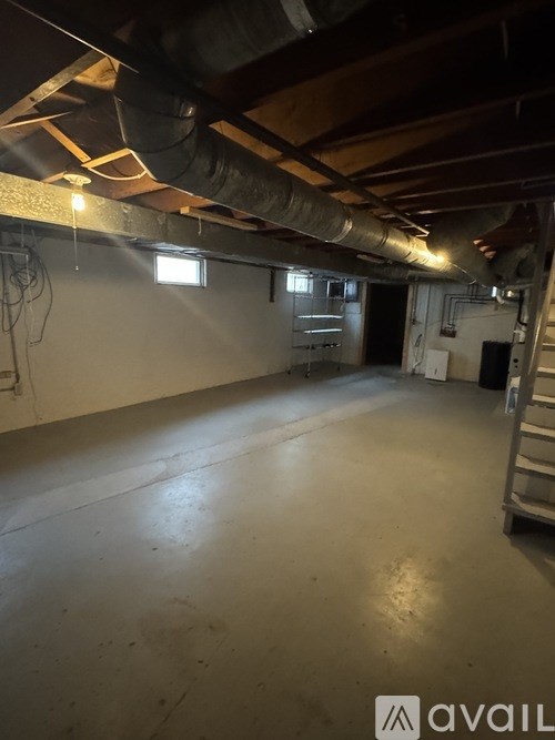 A spacious basement with a concrete floor and exposed ceiling beams.