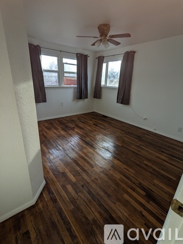 A room with wooden flooring and a ceiling fan.
