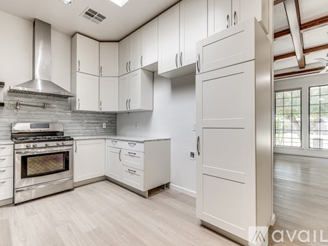 A modern kitchen with white cabinets and a stainless steel oven.