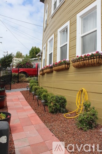 A yellow hose is on the ground next to a yellow house.