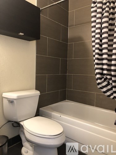 A white toilet sits next to a bathtub in a bathroom.