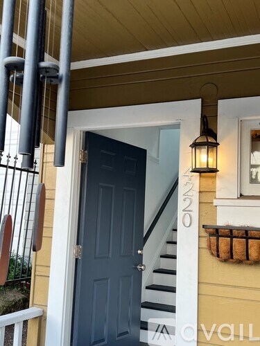 A blue door is on the left side of a white staircase.
