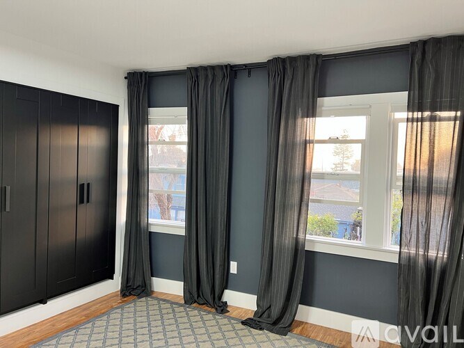 A room with grey curtains and a grey carpet.