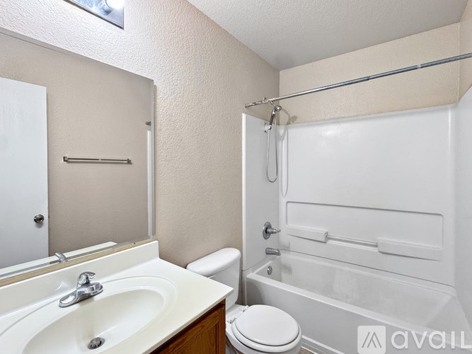 A white bathroom with a toilet, sink, and bathtub.