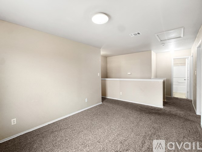 A spacious room with a carpeted floor and a bed in the corner.