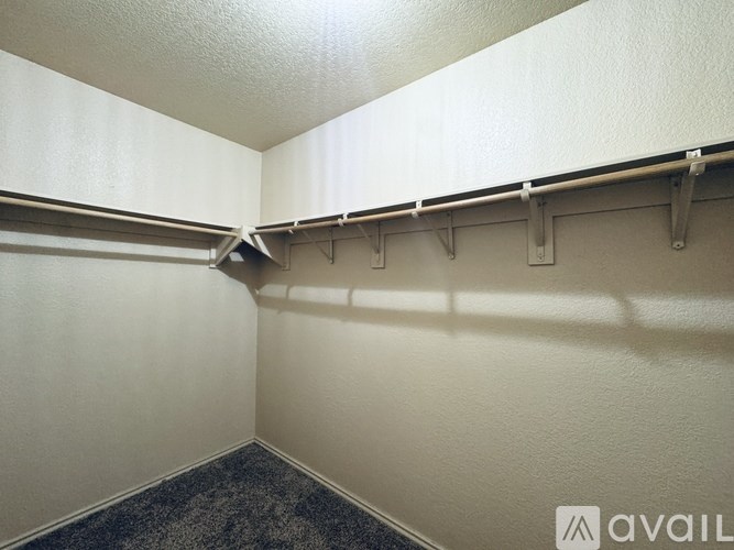 A room with a carpeted floor and a wall with a shelf.