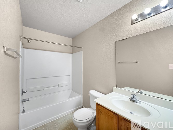 A white bathroom with a toilet, sink, and bathtub.
