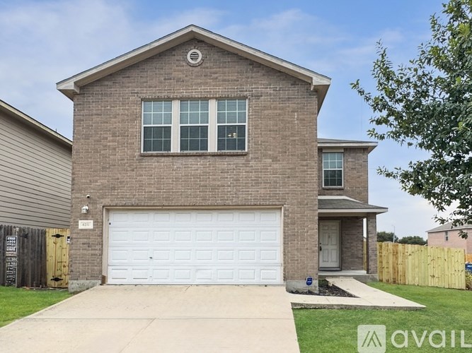 A house with a garage door and a driveway in front.