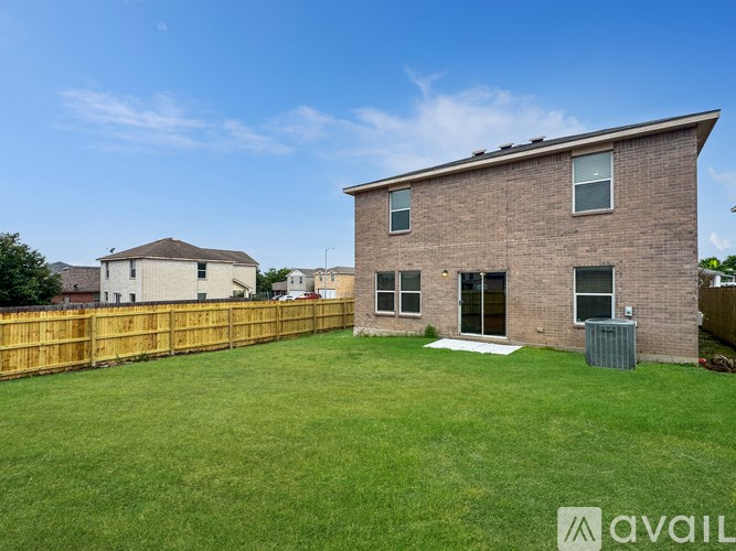 A house with a brown brick exterior and a green lawn in front.