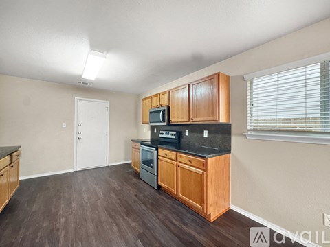 A kitchen with wooden cabinets and a black countertop.