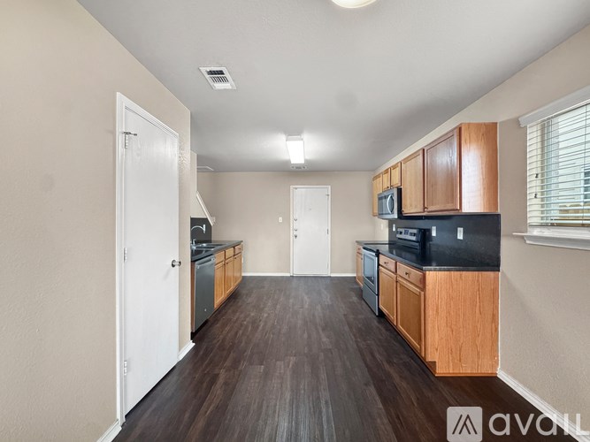 A kitchen with wooden cabinets and a black countertop.