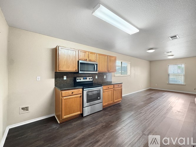 A kitchen with wooden cabinets and a microwave above the stove.