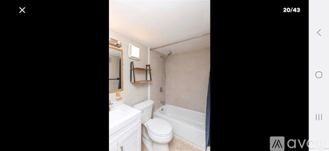 A white toilet in a small bathroom with a mirror above it.