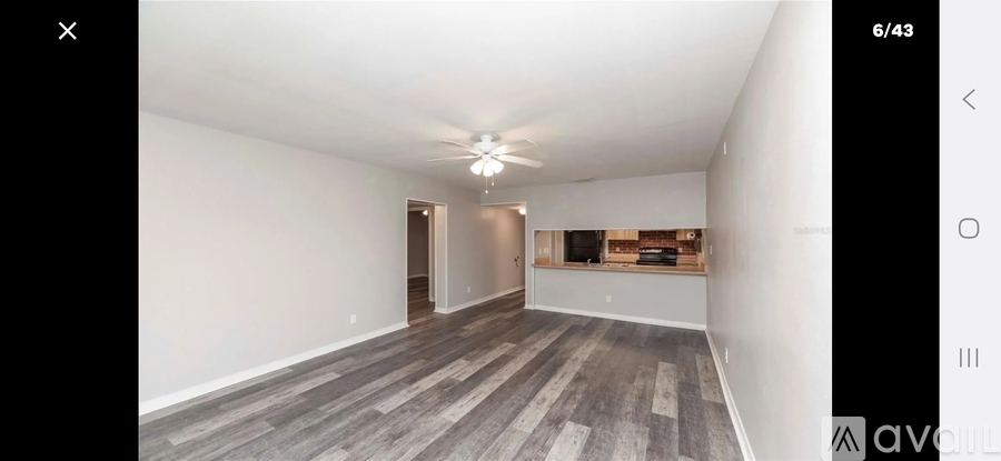 A spacious room with a grey floor and white walls.