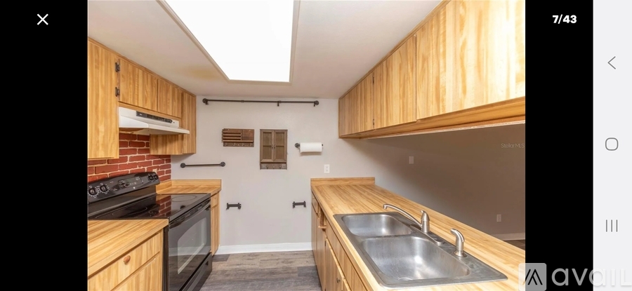 A kitchen with wooden cabinets and a brick backsplash.