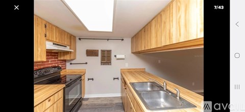 A kitchen with wooden cabinets and a brick backsplash.