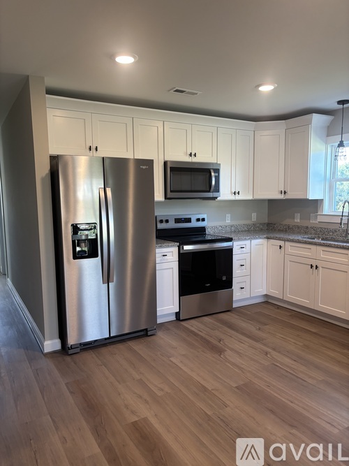 A kitchen with a stainless steel refrigerator and microwave.