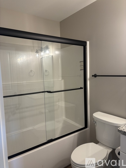 A white toilet sits next to a glass shower door in a bathroom.