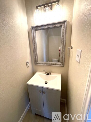 A bathroom with a sink and a mirror above it.