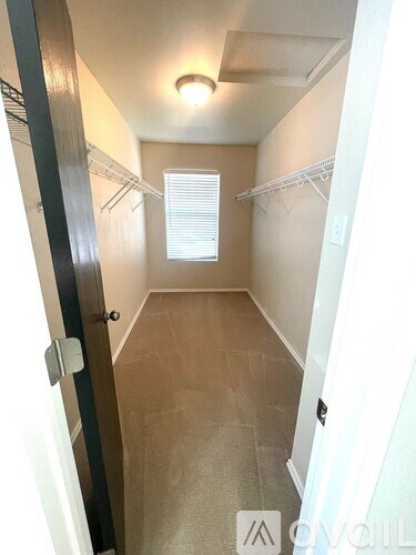 A hallway with a light on the ceiling and a window with blinds.