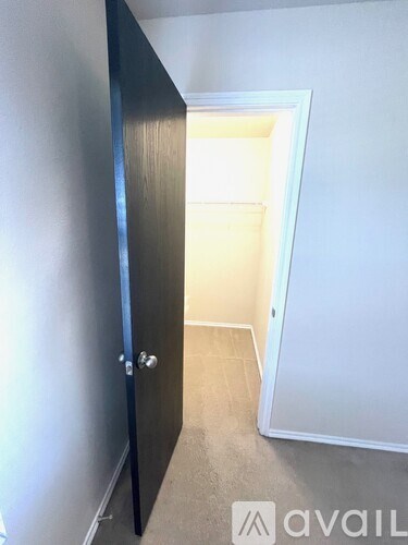 A black door is open to a white room.