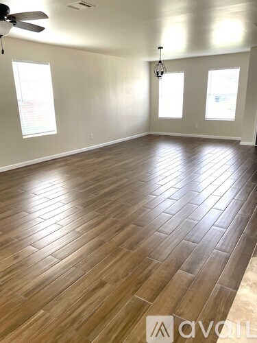 A room with wooden flooring and a ceiling fan.