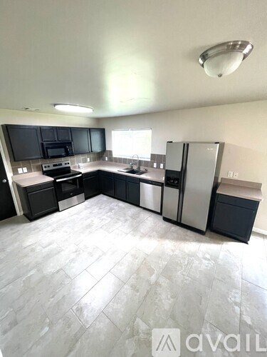 A kitchen with black cabinets and stainless steel appliances.