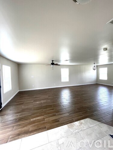 A room with wooden flooring and a ceiling fan.