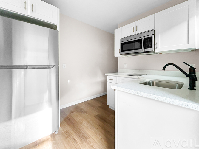 A kitchen with white cabinets and a white fridge.