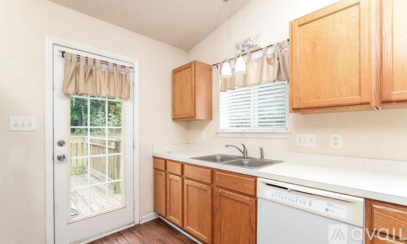 A kitchen with wooden cabinets and a white dishwasher.