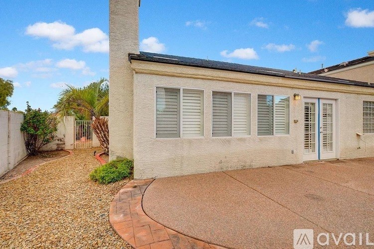 A room with a window covered in blinds and a carpet on the floor.