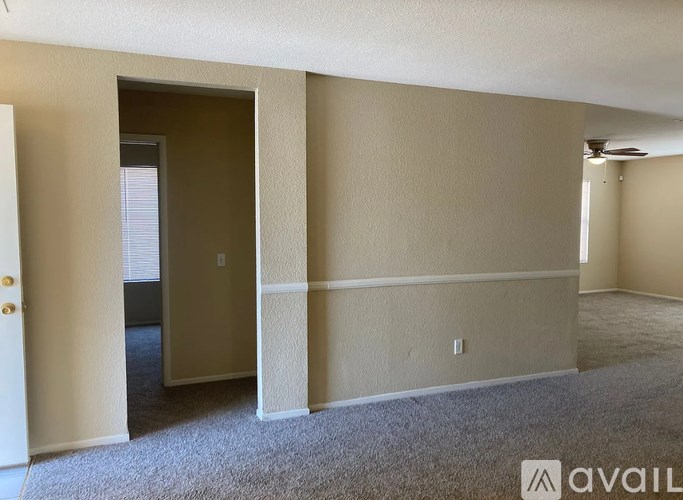 A room with a carpeted floor and a doorway leading to another room.