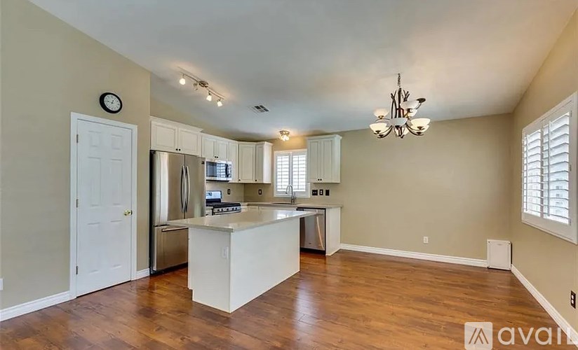 A kitchen with wooden floors and a white island.