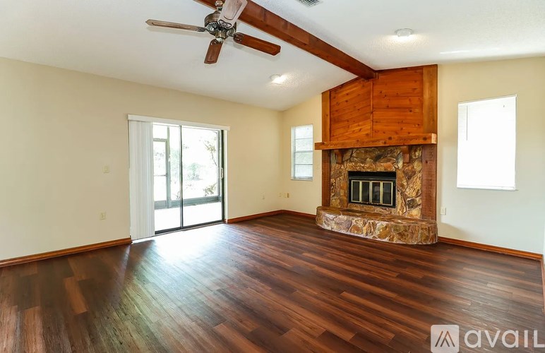 A spacious room with a ceiling fan and wooden flooring.
