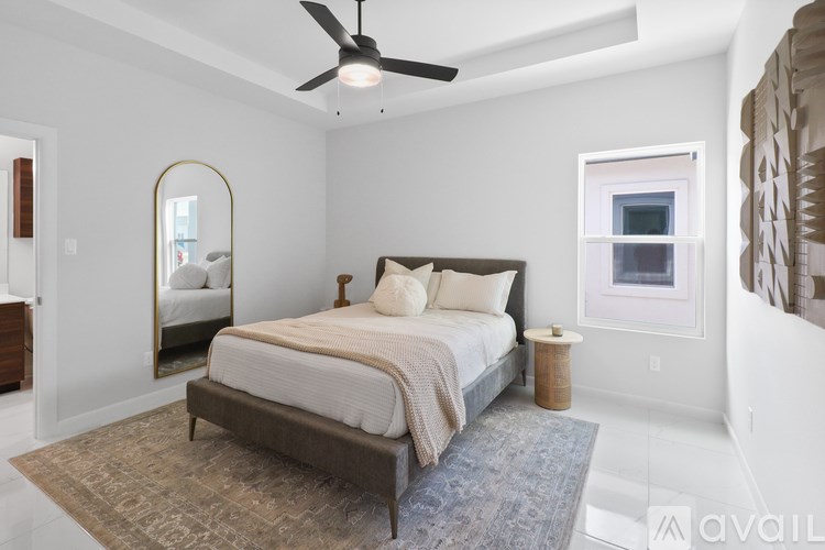 A bedroom with a large bed and a ceiling fan.