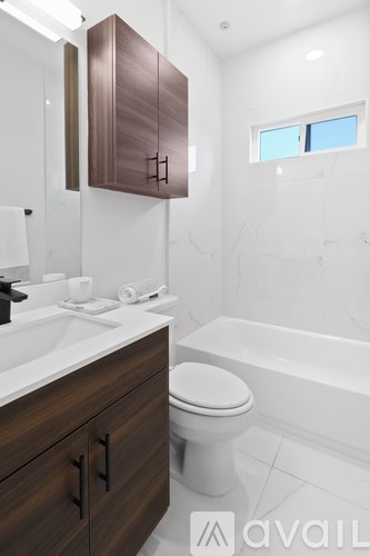 A modern bathroom with a white sink and a white toilet.