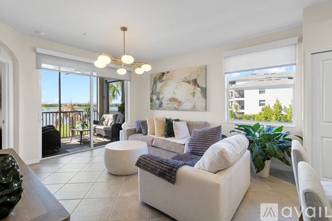 A living room with a white couch and a painting on the wall.