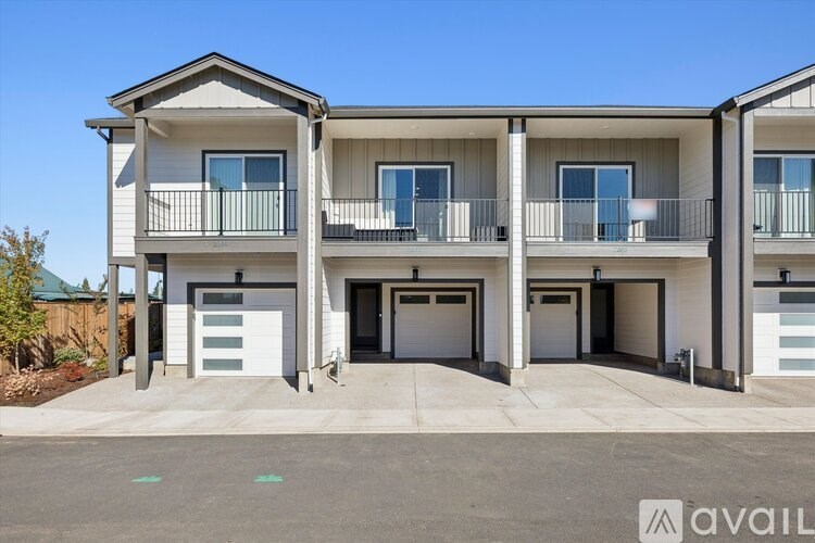 A modern two-story apartment building with a balcony on the second floor.