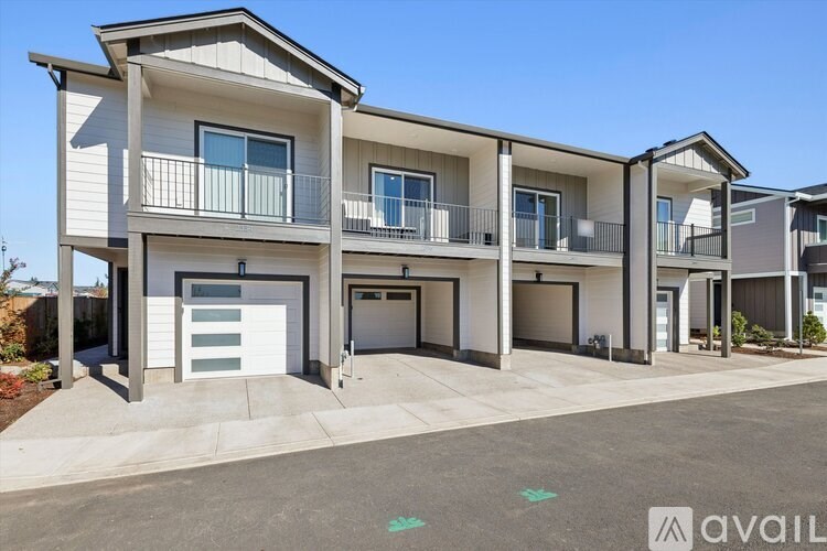 A modern two-story apartment building with a balcony on the second floor.