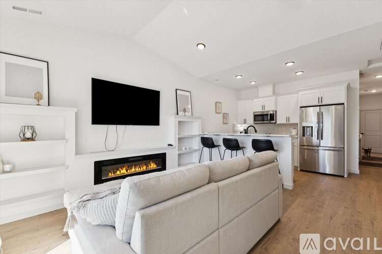 A modern living room with a fireplace and a grey sofa.