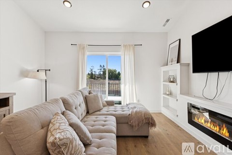 A living room with a large couch and a fireplace.