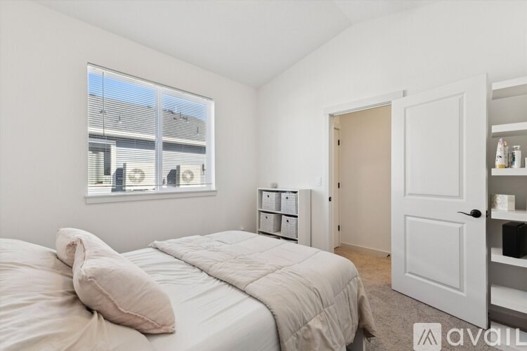 A bedroom with a large bed and a window overlooking a building.