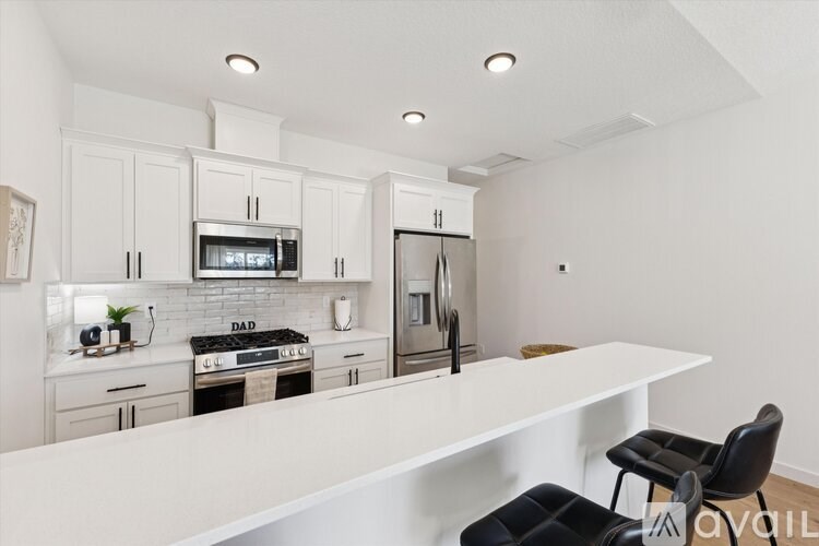 A modern kitchen with white cabinets and appliances.