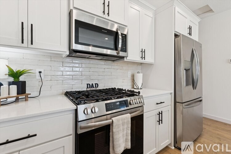 A kitchen with white cabinets and a black stove top.