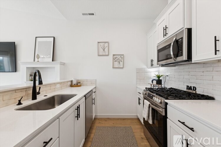 A kitchen with white cabinets and a black stove top.
