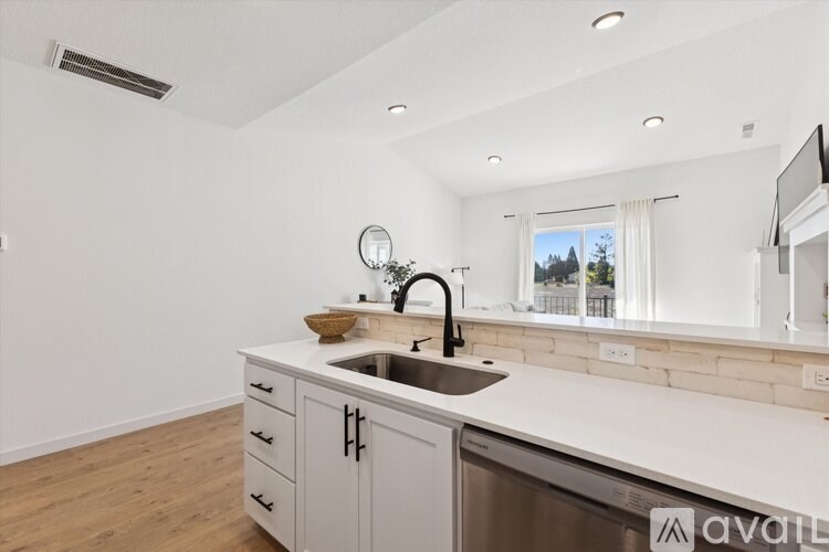 A kitchen with a sink, a mirror, and a window.
