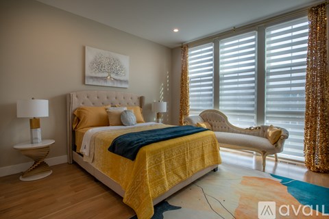 A bedroom with a large bed and a chair.