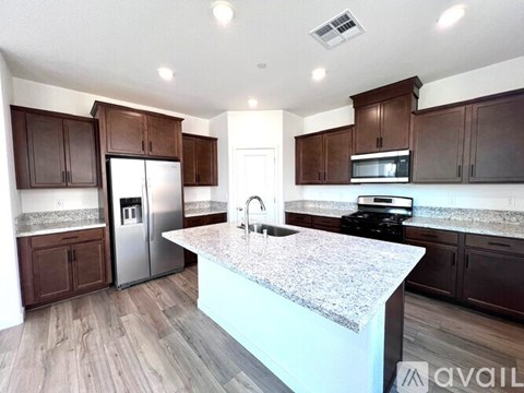A kitchen with brown cabinets and a granite countertop.