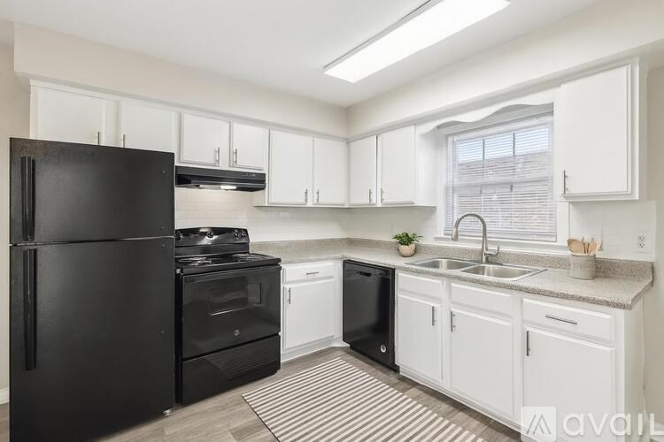 A kitchen with black appliances and white cabinets.