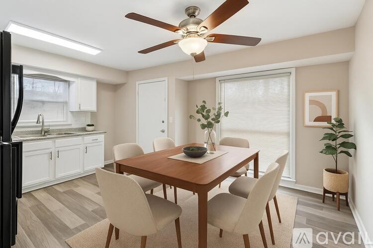 A dining room with a wooden table and chairs.